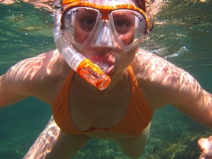 Chica explorando el océano haciendo snorkelling